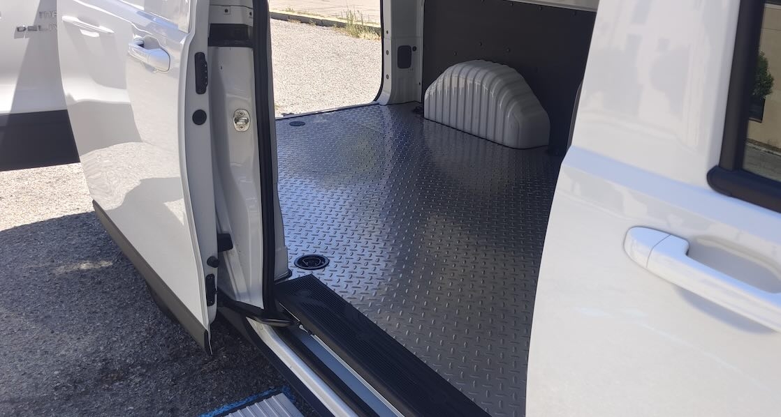 De aluminio es el piso del compartimento de carga.
