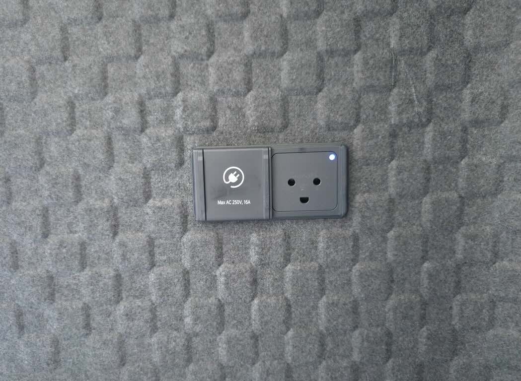 Detalle de la sonriente conexión de 220 V del compartimento de carga.