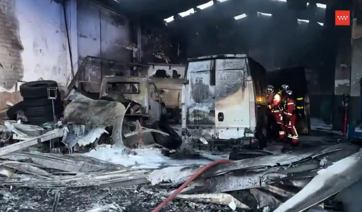 Tres vehículos calcinados por el incendio de un taller de camiones en San Fernando de Henares (Madrid)