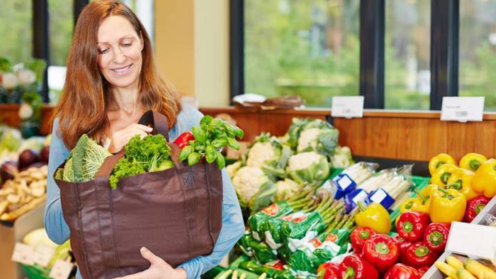 Consumidora comprando fruta y verdura en un supermercado - Archivo
