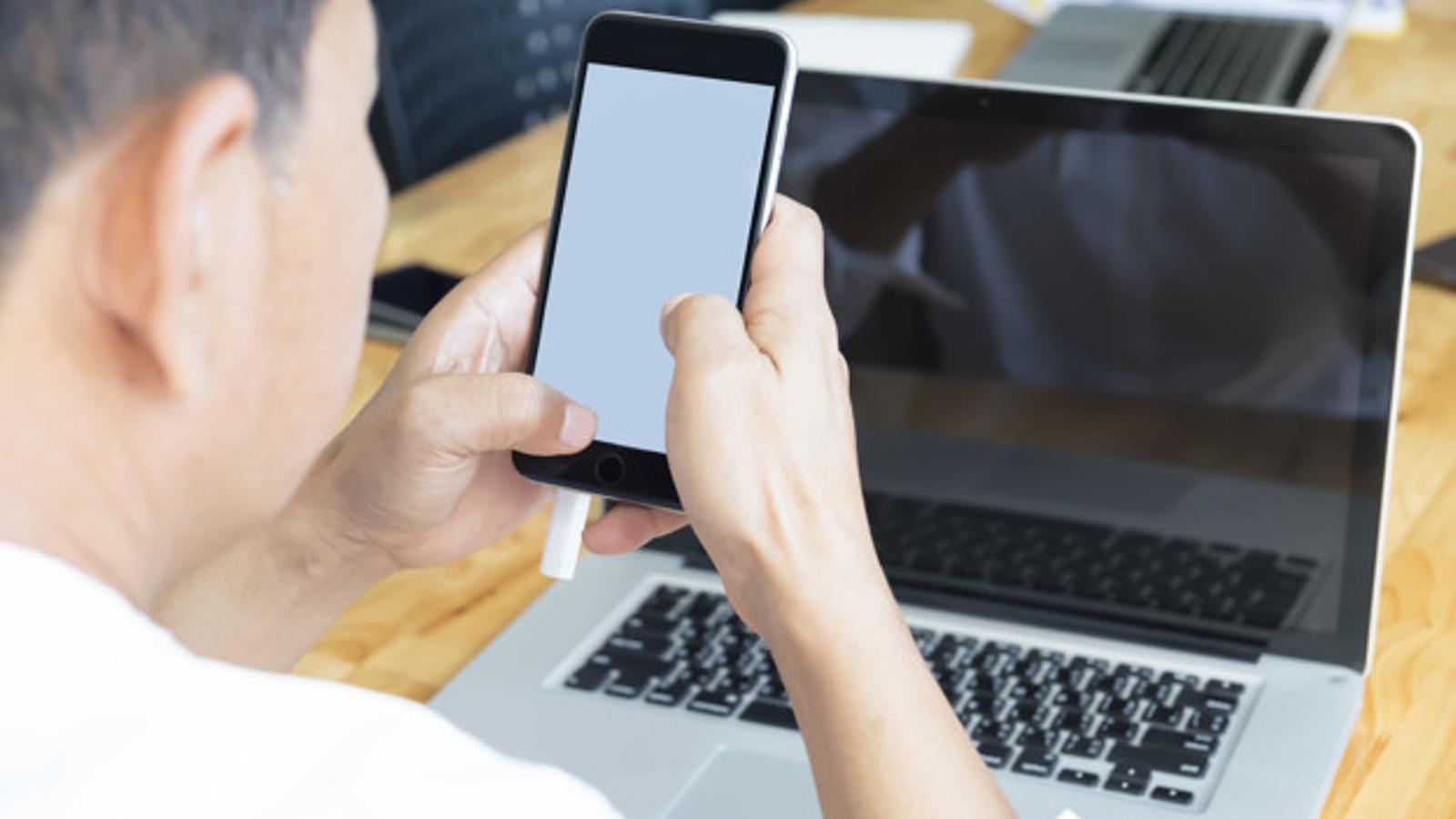 Un hombre habla por el móvil en la oficina - Archivo