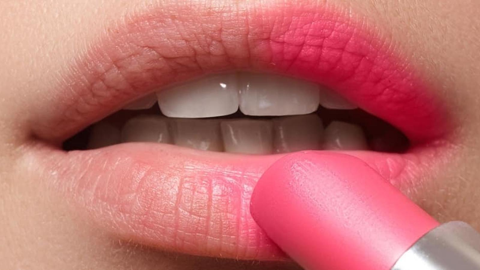 Consumidora aplicando un pintalabios - Archivo