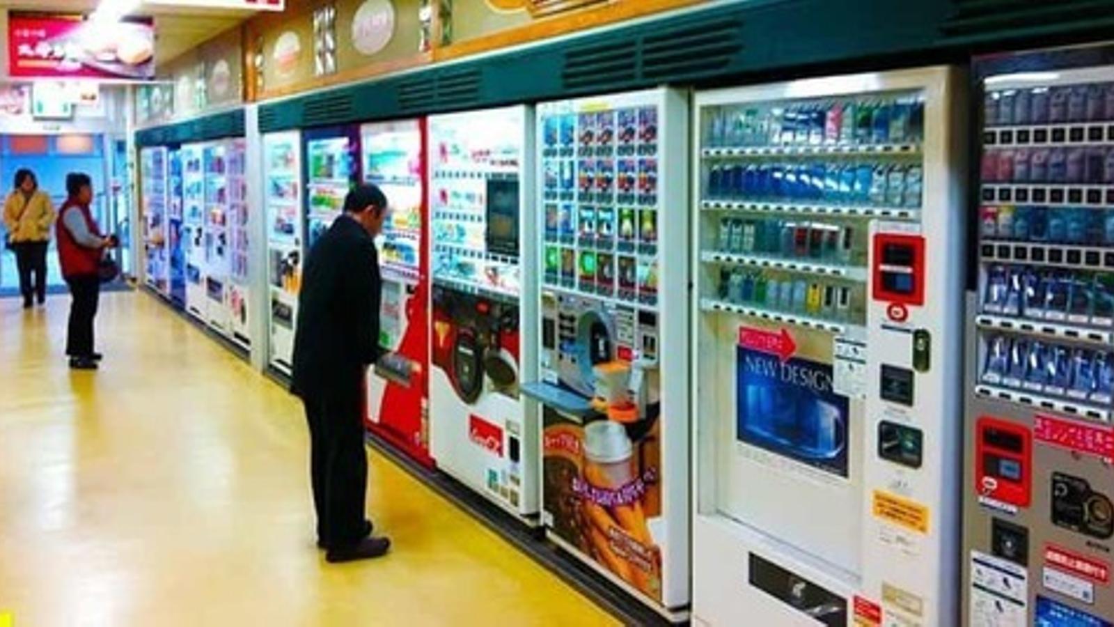 Consumidores comprando en máquinas de vending - Archivo