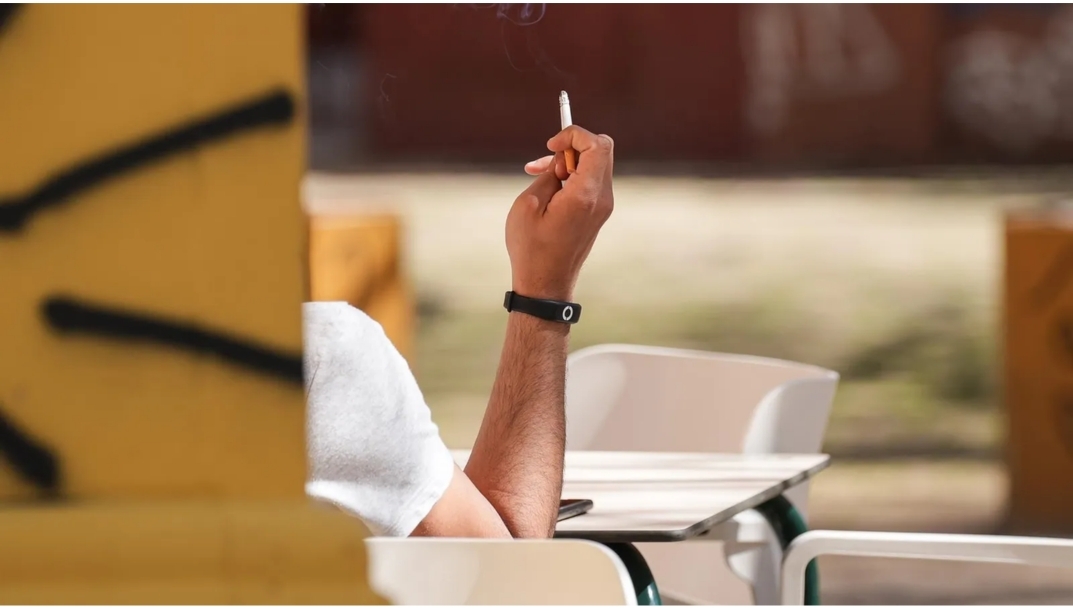 Cliente fumando en la terraza de un bar. - 